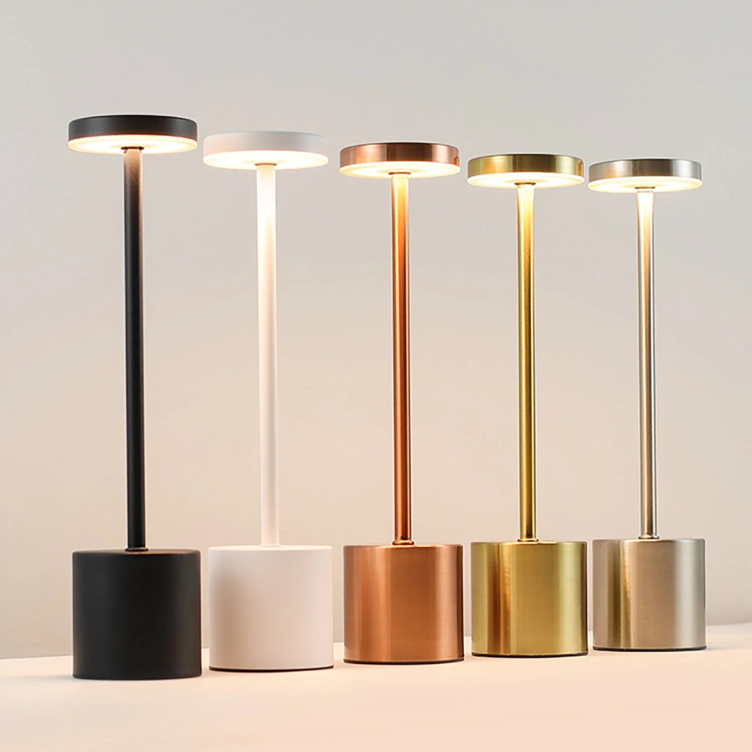 Set of five standing lamps in black, white, bronze, gold, and silver on a neutral background